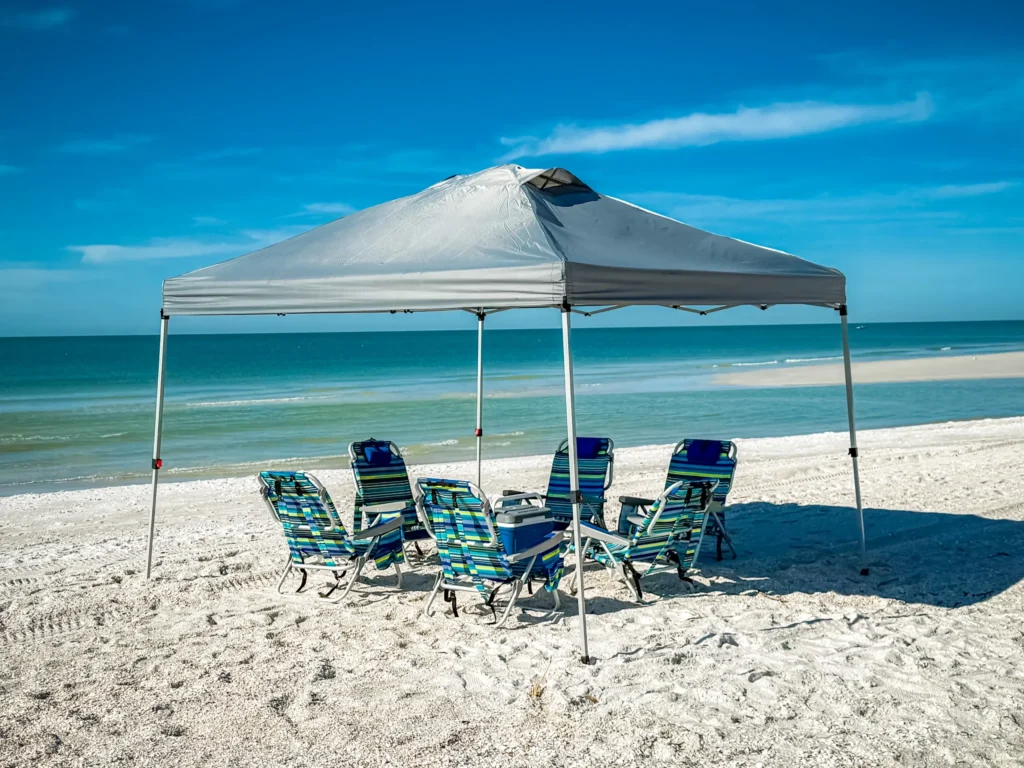 Triple G's Rentals beach equipment including chairs, umbrellas, and wagons, set up on an Anna Maria Island beach, ready for stress-free vacation days.