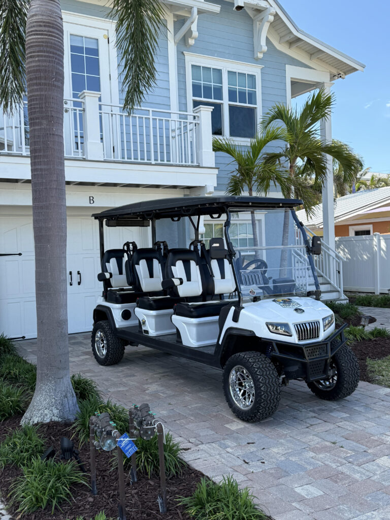 A premium 6-passenger street-legal golf cart from Triple G's Rentals parked in Siesta Key, featuring 'Out the Door' pricing and free delivery.